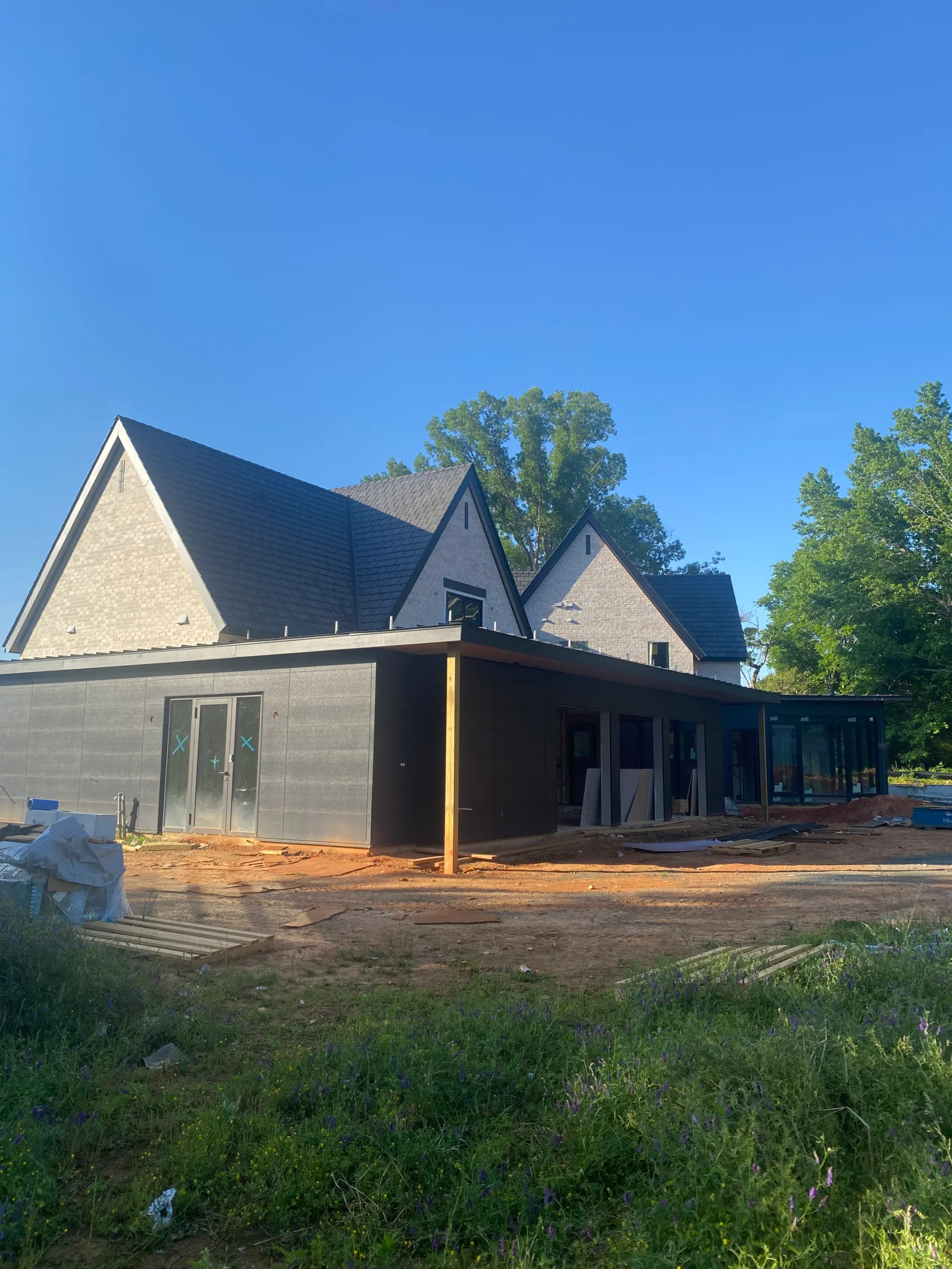 Dark asphalt shingle roof with multiple gables on new residential construction with brick exterior